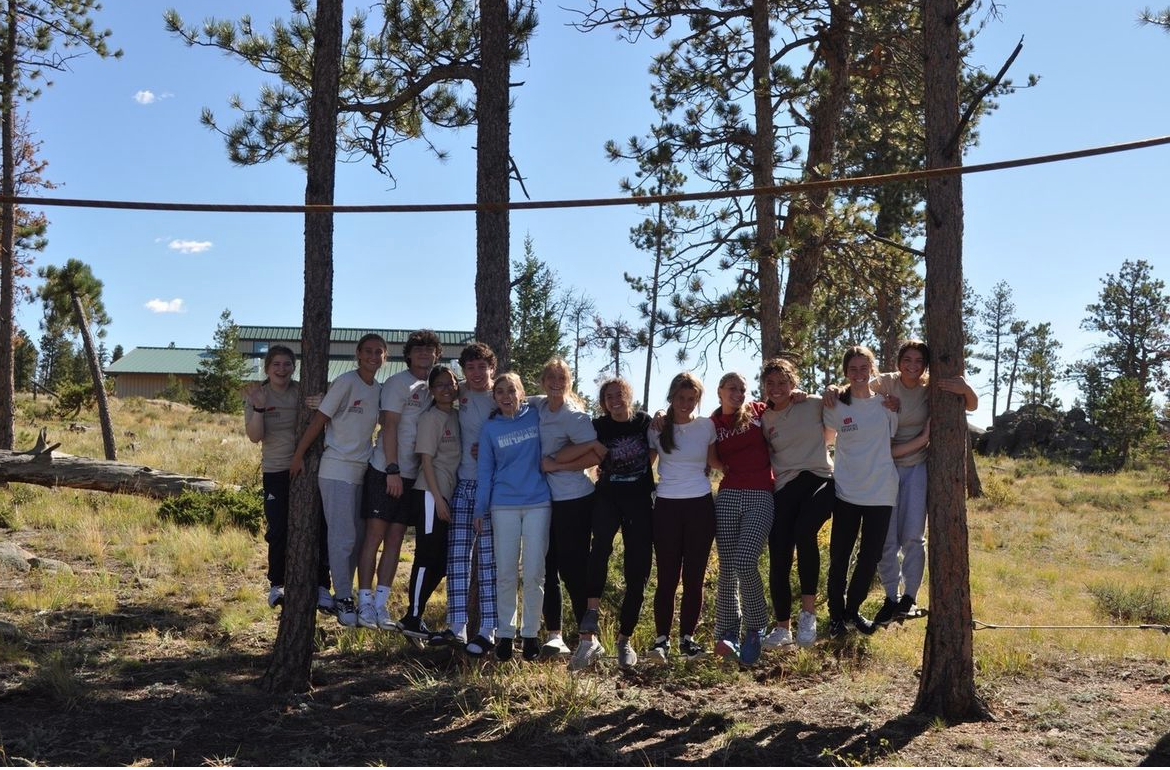 group of students standing amongst trees