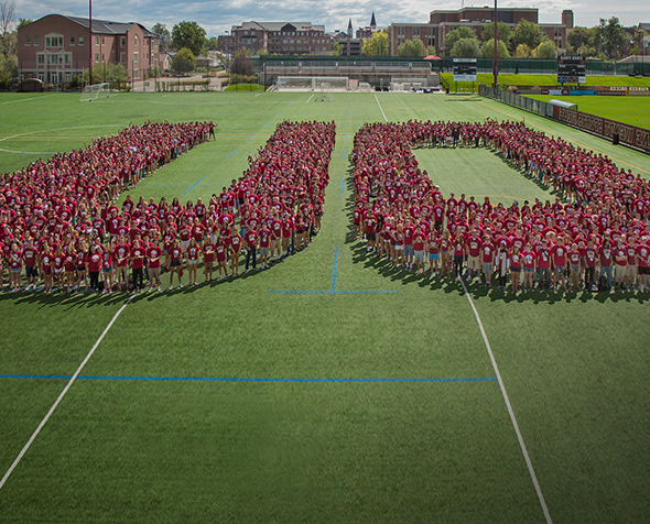 Students form a DU formation on the football field.