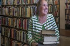 A woman carrying a stack of books.