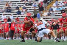 A DU lacrosse player in a face off with a Syracuse lacrosse player.