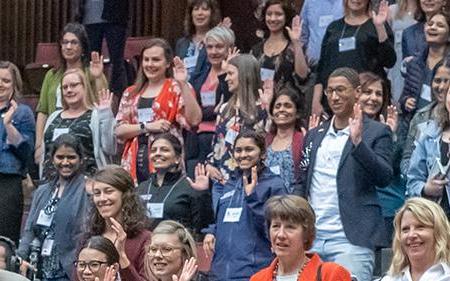 audience standing with hands raised